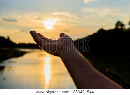 Male Hand Pointing At Sun In Blue Sky At Evening Time Admire Landscape. Capture Moment To Admire Sun