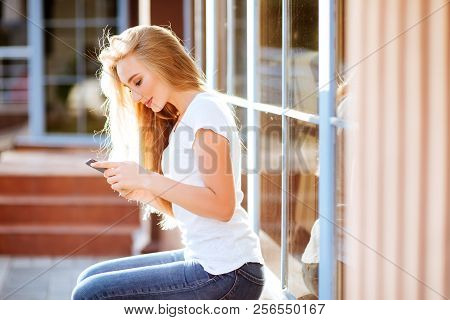 Attractive Smiling Woman Using Smartphone Outdoors. Lefestyle Concept