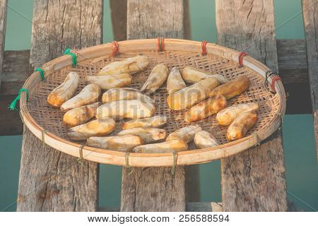 Close Up Sun-dried Banana Put On Wooden Basket Over Sea That Preserved Bananas By Peeling And Drying