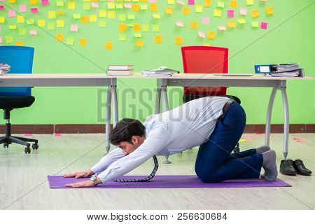 Man in the office with many conflicting priorities doing exercis