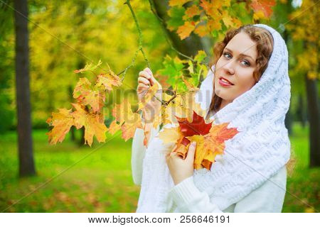 beautiful young plussize model with long curly hair in the autumn park