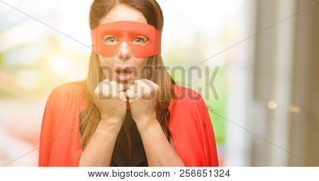 Middle age super hero woman wearing red mask and cape terrified and nervous expressing anxiety and panic gesture, overwhelmed