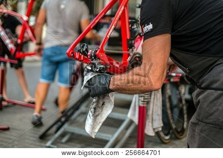 Malaga, Spain - August 27, 2018. Senior Man Hands Cleaning The Chain Bike, Doing Maintenance