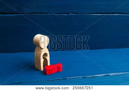 A Wooden Figure Of A Woman With A Void From Which A Red Child Fell. The Concept Of The Loss Of A Chi