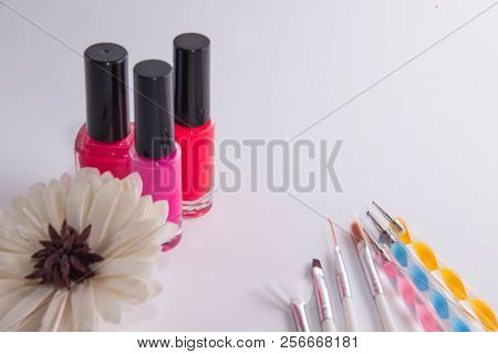 Three Jars Of Lacquer Siyat On A White Background, Next To Them Are Tassels For Manicure And A Flowe