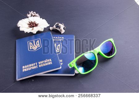 Two Ukrainian Overseas Passports On A Black Background With Glasses And A Flower