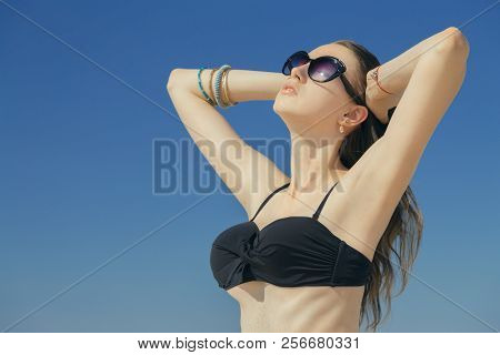 Beautiful Young Woman In Swimsuit Under Sun Rays Tanning, Toned Image