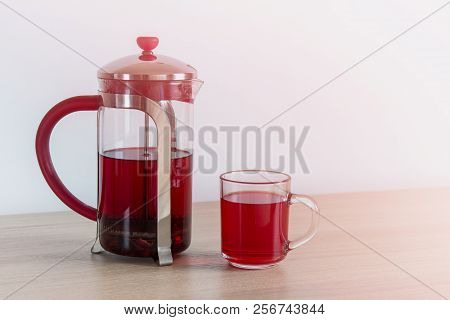 Hibiscus Tea In A Tea Pot. Karkade Tea Or Red Sorrel Tea In Glass Pot And Cup On White Background Wi
