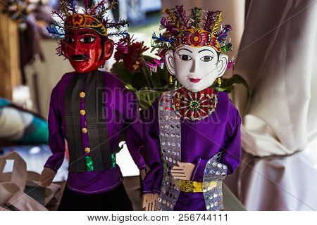 Two Indonesian Dolls With White And Red Faces In Traditional Folk Costumes