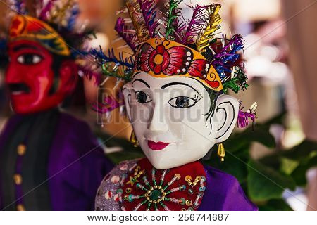 Two Indonesian Dolls With White And Red Faces In Traditional Folk Costumes