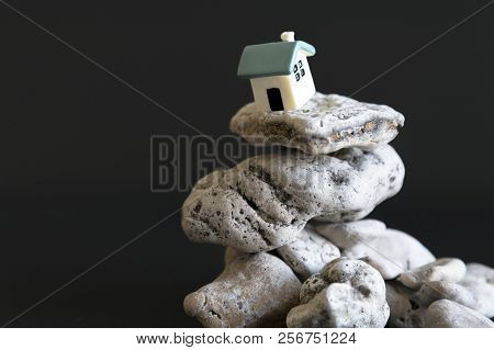 House On The Edge Of The Abyss On A Black Background. The Concept Of A Dangerous Situation In Life A