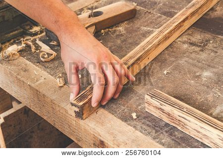 Carpenter Examining Quality Fn The Old Wooden Frame.