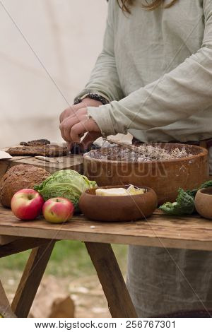 Medieval Food Preparation Including Bread, Butter, Cheese And Fruit In Wooden Bowls Or Trenchers