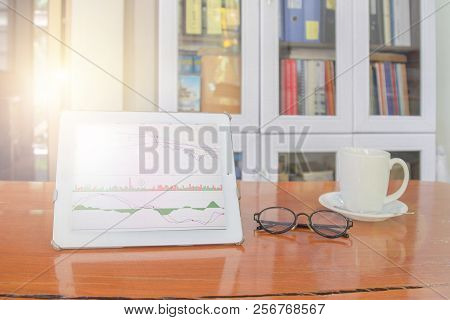 Mock Up Image Of White Tablet Pc With Black Blank Screen And Coffee Cup On Wooden Table In Blur Offi