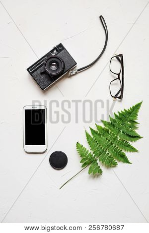 Busines Flat Lay Of Office Stuff On White Table. Notebook, Pencil. Glasses, Laptop, Fern
