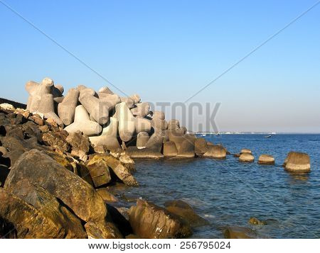 Concrete Breakwaters. Seascape With Concrete Tetrapodes To Protect Coastal Structures From Destructi