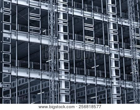 Monochrome Blue Tinted View Of A Large Building Development Under Construction With Steel Framework 