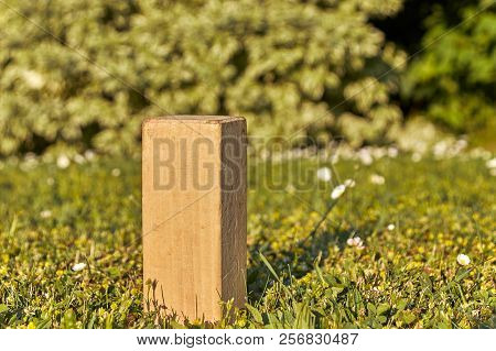 A Wooden Stone Of The Sweden Viking Game Kubb Stands Alone In The Sun On A Green Meadow