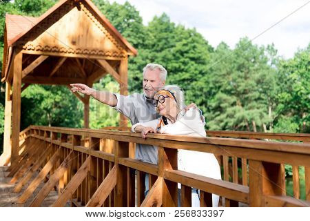 Handsome Elderly Man Showing His Appealing Wife Nice Spot In The Park