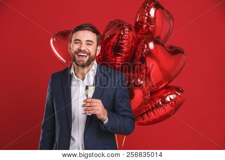 Red Balloons In The Hands. Handsome Young Man Holding Heart Shaped Baloon