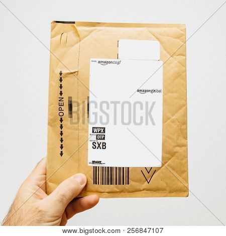 Paris, France - Feb 5, 2018: Man Holding In Hand Parcel Enevole Against White Background From Amazon