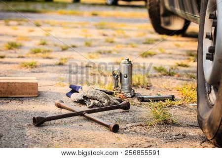 Manual Socket Wheel Wrench And Jack Lying On Ground. Tire Car Repair Objects Concept.