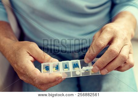 Scaled Up Look On Elderly Gentleman Taking Medication