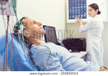 Nervous Gentleman Getting Brain Analyzed By Electroencephalography Machine