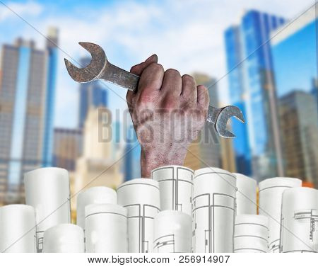 Hand Holding Pilers With Architect Plans And City Background