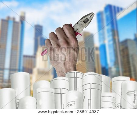Hand Holding Pilers With Architect Plans And City Background