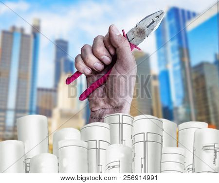 Hand Holding Pilers With Architect Plans And City Background