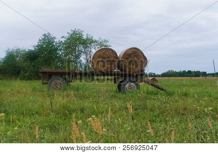 Two Twisted Hay Rolls On A Cart In The Field