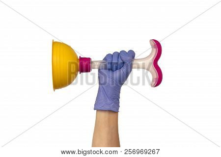 Female Hand In A Purple Rubber Glove Holds A Yellow Plunger With A Pink Plastic Handle. Isolate On W