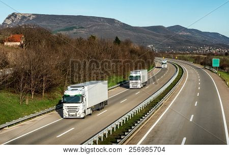 Fleet Or Convoy Of Trucks In Line On A Country Highway