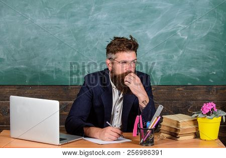 Paperwork Part Of Teachers Life. Check Homework. Teacher Bearded Hipster With Eyeglasses Sit In Clas