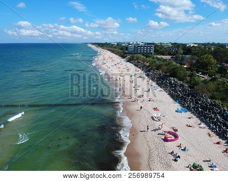 MIELNO, POLAND - 02 SEPTEMBER 2018 - Aerial view on sunny beach with tourists at baltic sea on Mielno city