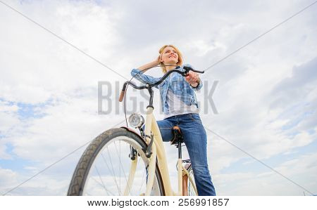Girl Rides Bike Sky Background. Woman Rent Bike To Explore City Copy Space. Bike Rental Shops Primar
