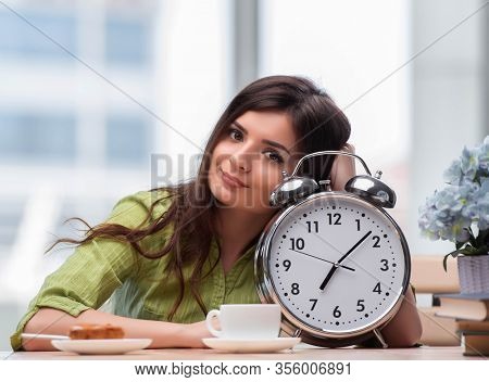 Student with gian alarm clock preparing for exams