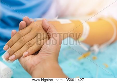 Husband Holding Wife Hand Giving Normal Saline Solution Or Sodium Chloride After Surgery In Hospital