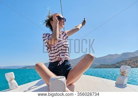 Beautiful Teenager Girl Enjoys Summer Sea Trip, Female Sitting On Front Side Of Small Pleasure Boat.