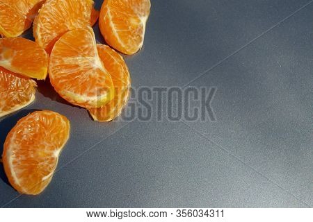Pieces Of Orange Mandarin On A Gray Background
