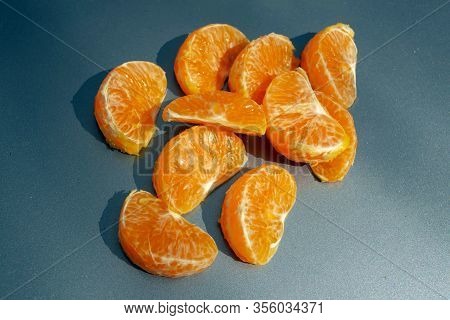 Pieces Of Orange Mandarin On A Gray Background