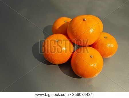 Ripe And Juicy Tangerines On A Gray Background