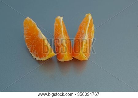 Pieces Of Orange Mandarin On A Blue Background