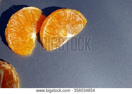 Pieces Of Orange Mandarin On A Gray Background