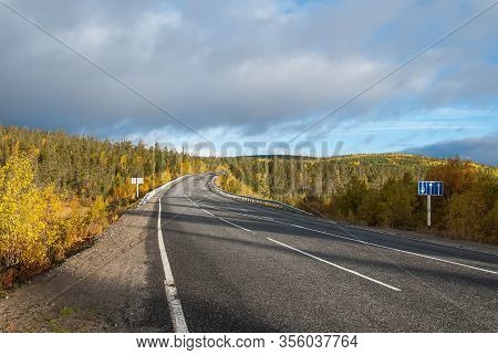 Kola Highway, Kola Peninsula, Murmansk Region. Northern Country Road Among Hills With Colorful Autum