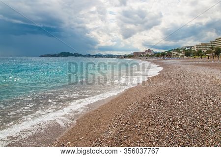 Sand And Pebble Beach On The Coast In Faliraki, Kallithea. Rhodes, Greece