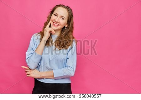 Stylish Caucasian Girl In A Pale Blue T-shirt Photographed For Tests In A Magazine On A Pink Backgro