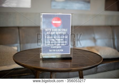 Copenhagen, Denmark - March 17, 2020: A Sign In A Cafe Informing About Closed Tables And Minium Dist