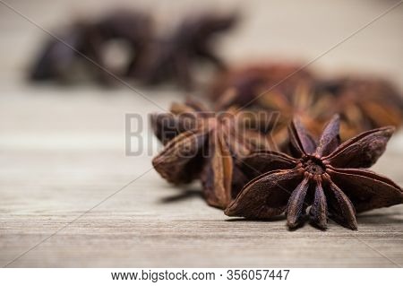 Star Anise With And Without Seeds, Closed, On A Light Wooden Surface. Spice For The Recipe. Beautifu